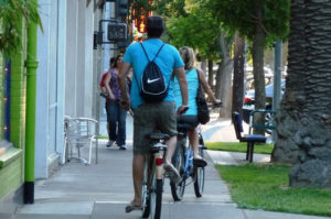 Sidewalk bicycling in Midtown Sacramento on a popular stretch of J Street without bike lanes.