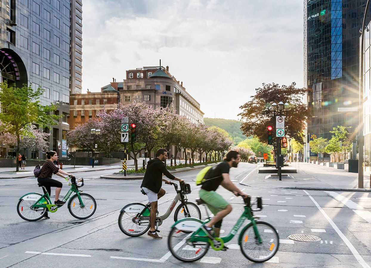 Three cyclists ride across an intersection.