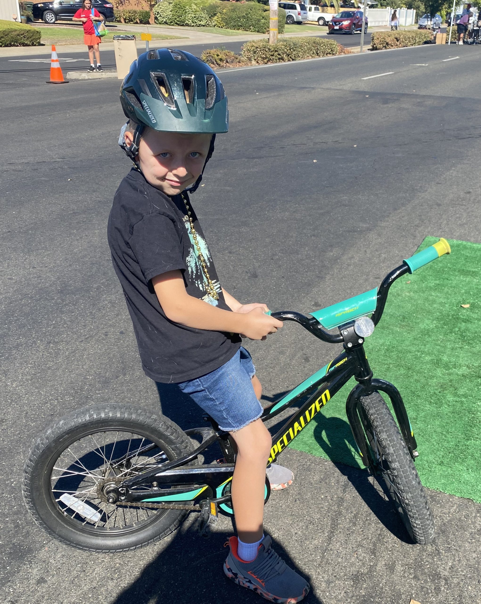 A boy sits on his bike in the street.