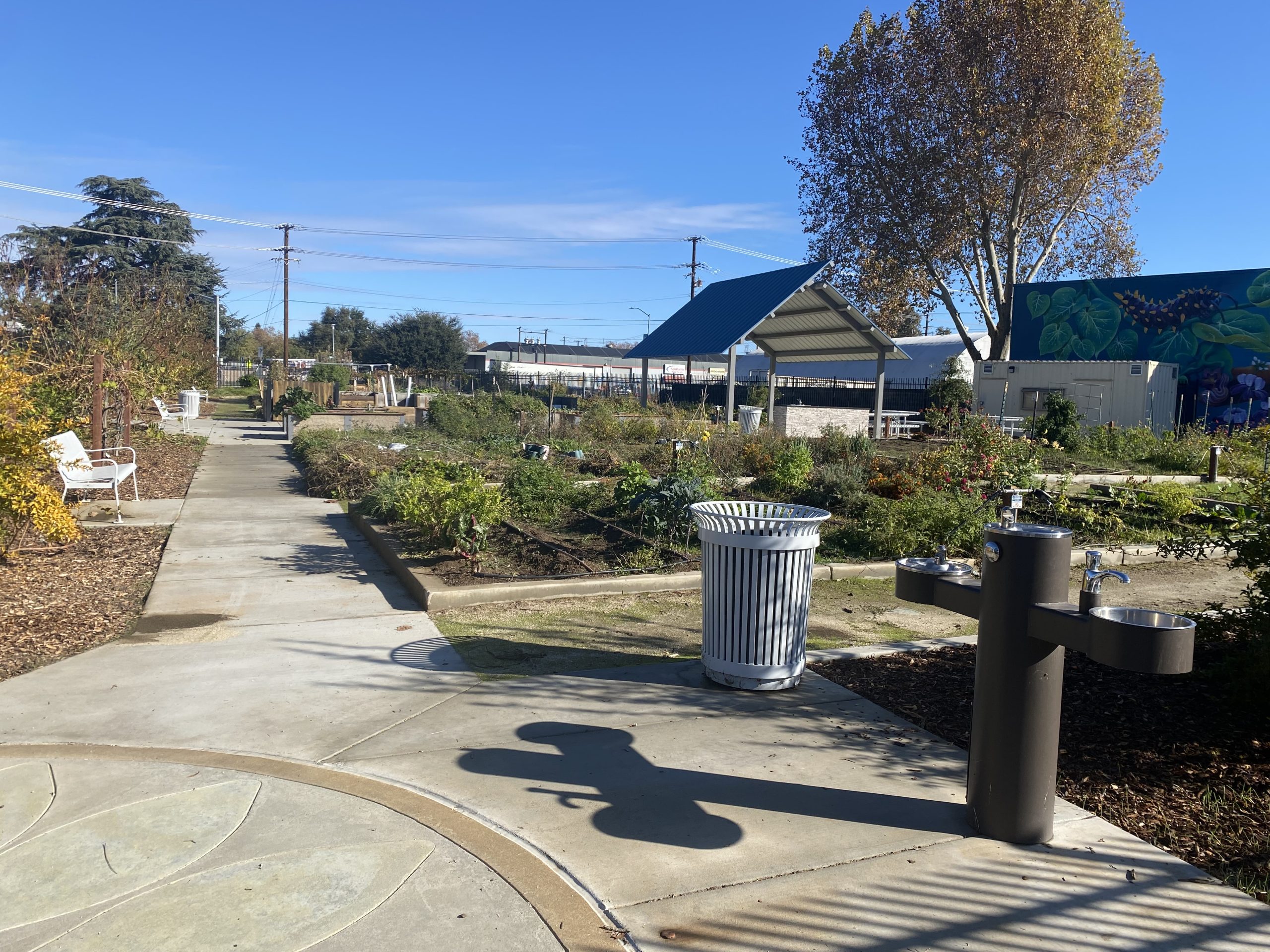 A large garden with benches and a water fountain.