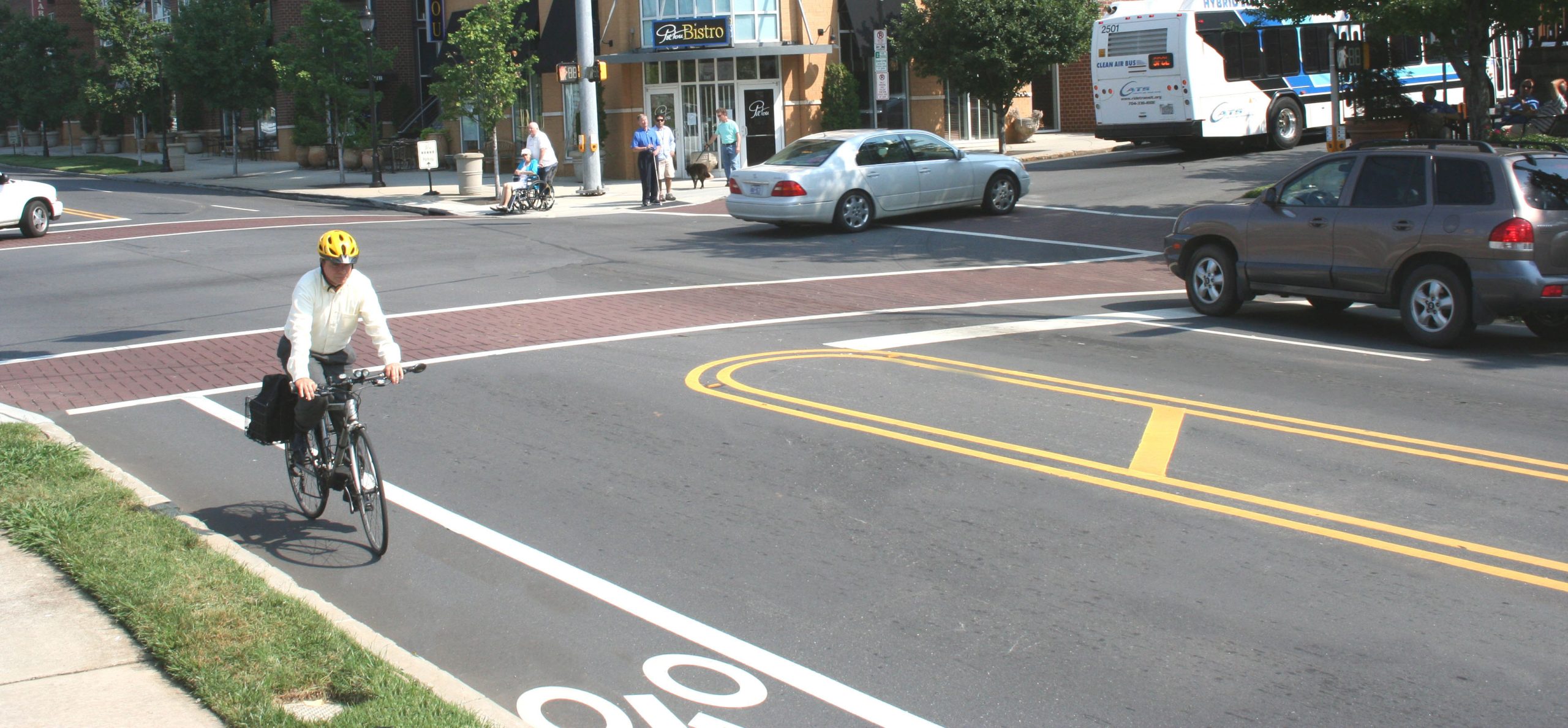 A cyclist rides down a street in a bike lane.