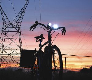 A bike sits on a hill with the sunset.