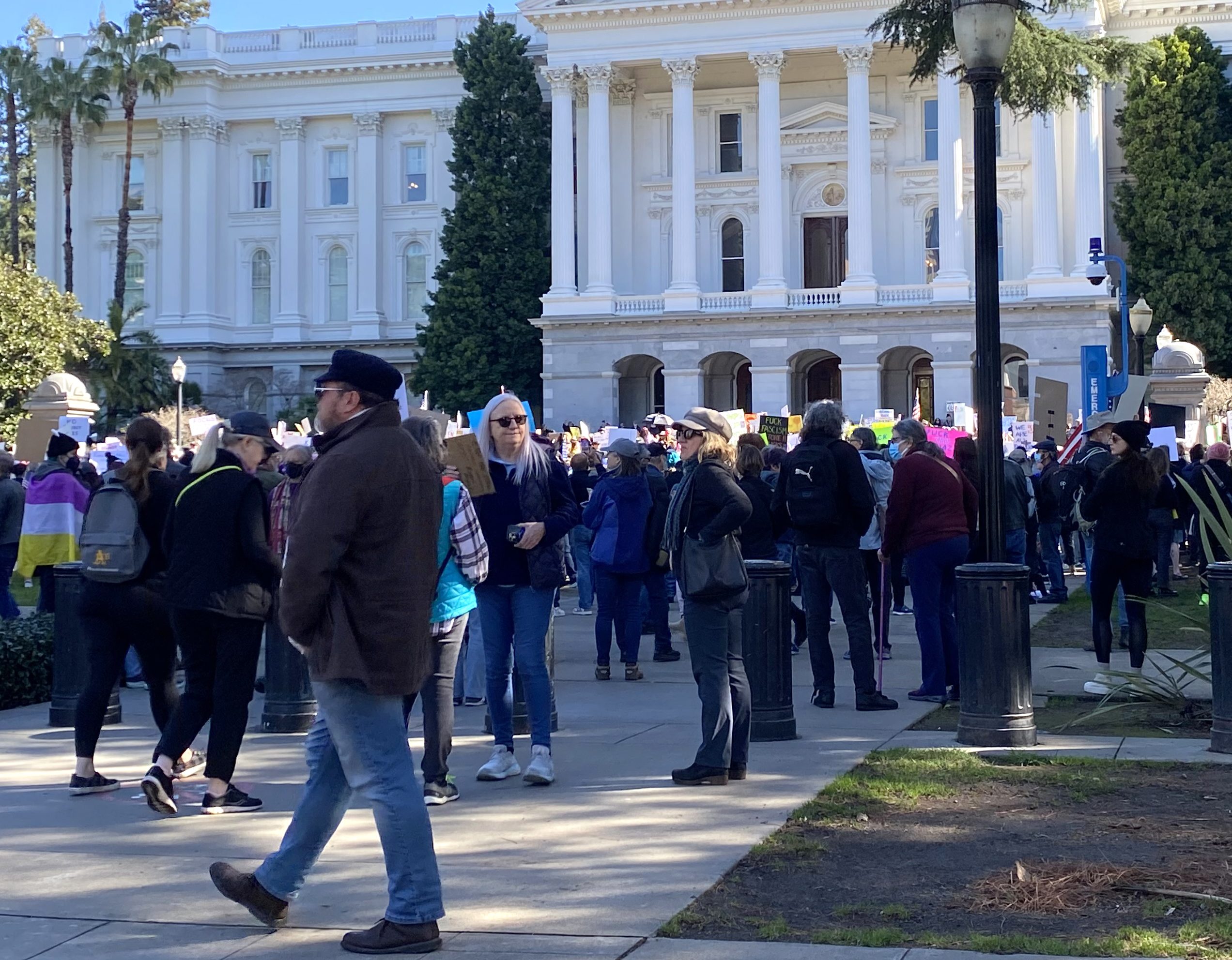 A large group of people gathers on the steps of the California capitol.