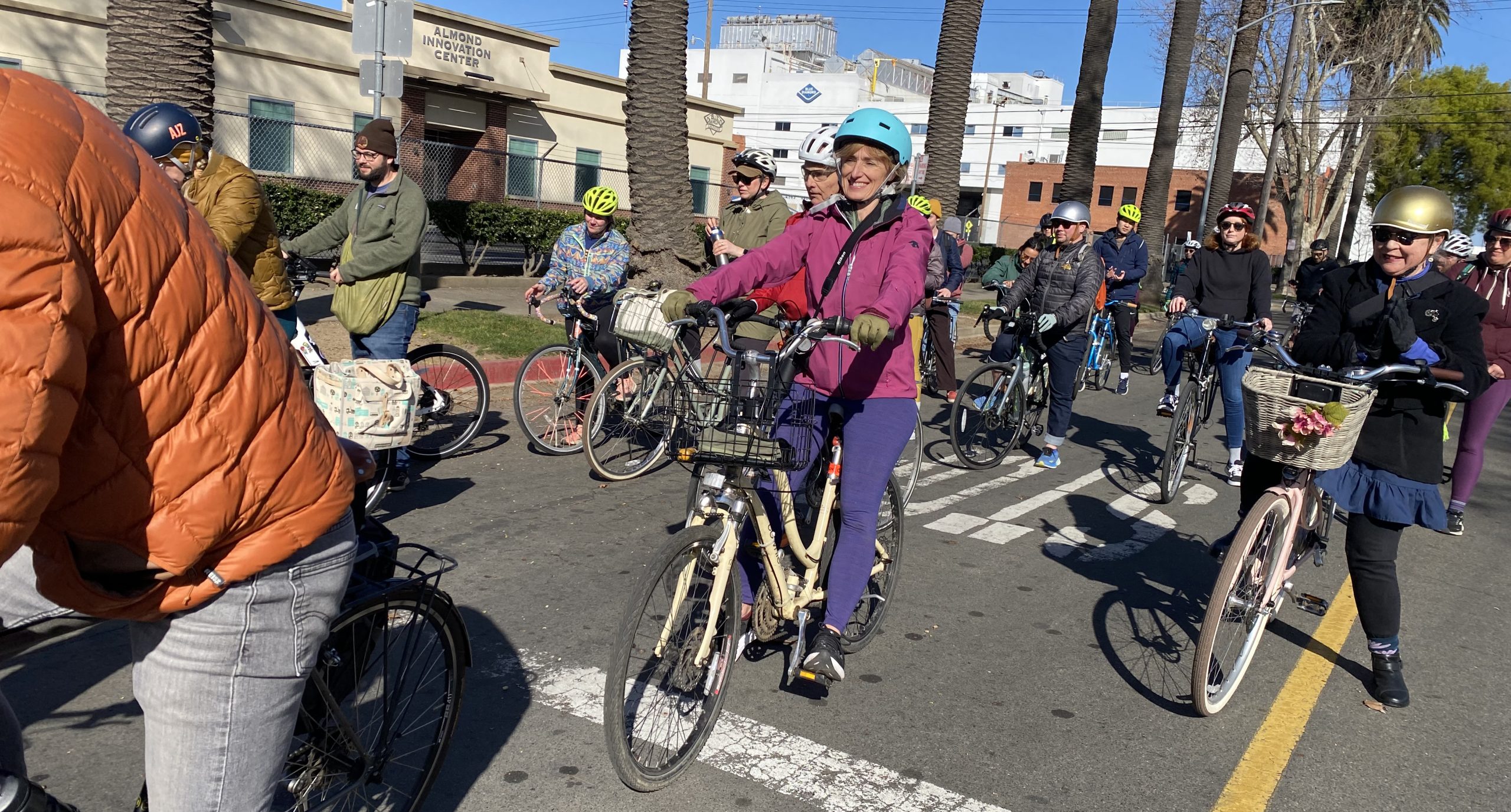 A group of cyclists ride their bikes on a city street.